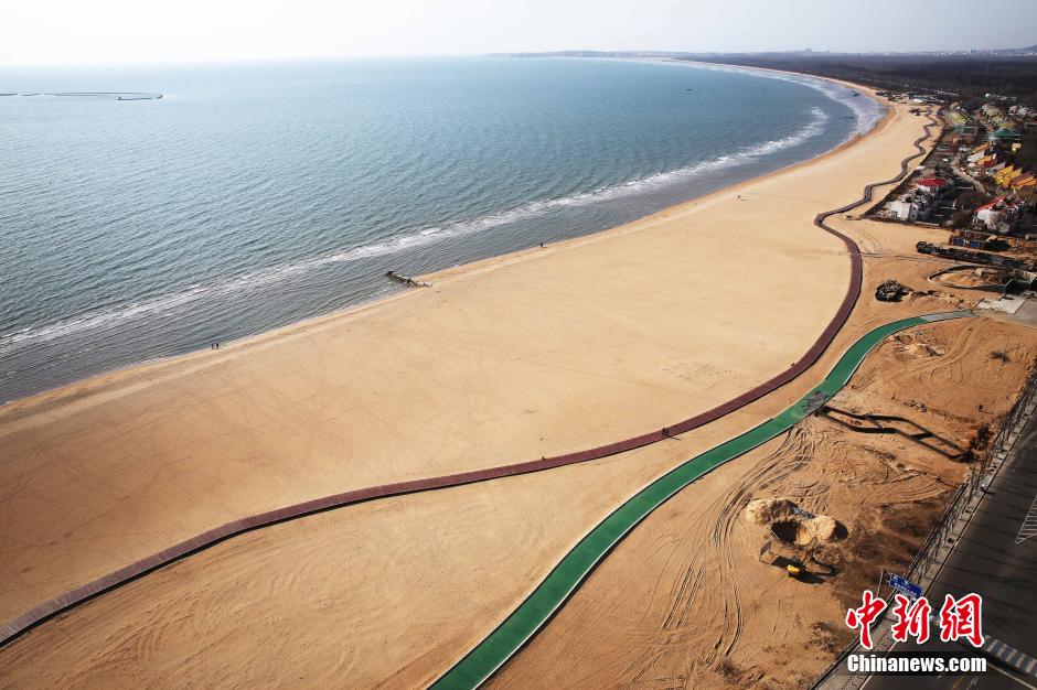 3月13日，秦皇島萬米臨海沙灘木棧道。據(jù)了解，該木棧道全長(zhǎng)約4200米，與北戴河區(qū)原有的7500米木棧道對(duì)接后全線總長(zhǎng)度1.17萬米，整個(gè)木棧道東起秦皇島體育基地游船碼頭，西至北戴河濕地公園，呈波浪形蜿蜒10.4公里海岸線。 中新社發(fā) 曹建雄 攝 CNSPHOTO